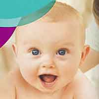baby smiling at balloons