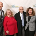 Dulles Area Association of Realtors members in long winter coats and suits ready to present awards