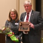 dulles area association of realtors presenting an award for phyllis stakem at the holiday party