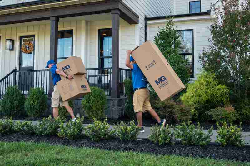 two movers carrying boxes