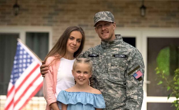 military family standing in front of new home