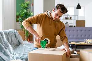 young man packing a box