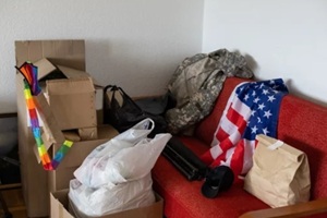 boxes with things to move, military uniform and flag of America